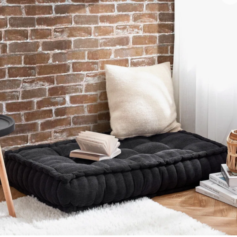 Cozy floor cushion reading nook in a small apartment