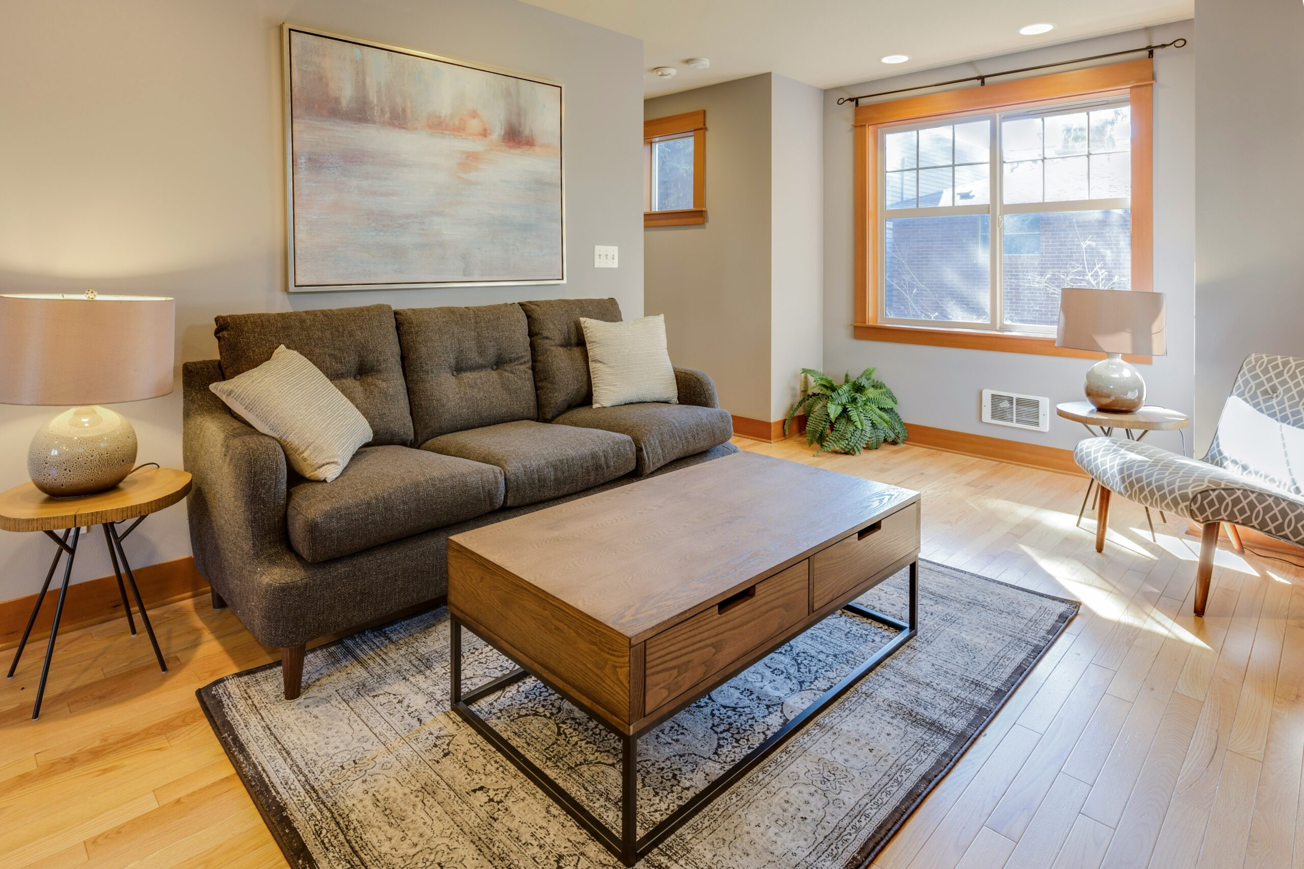 Warm organized small living room with compact furniture, clear walkways, and natural light